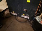 a black box with a yellow sticker on it in a garage