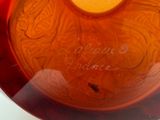 a glass bowl that has a yellow candle inside of it