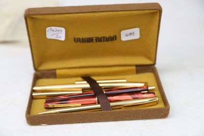four pens in a box on a white surface