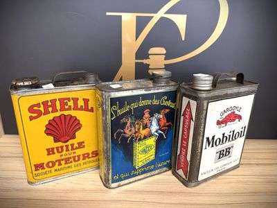 three vintage shell oil cans sitting on top of a wooden table