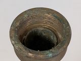 a small metal vase that is sitting on a table