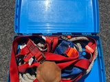 une boîte bleue remplie d'objets divers, posée par terre