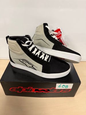 une paire de baskets noires et blanches posée sur une boîte