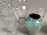 a lot of glass vases and glasses on the table