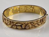an image of a gold bracelet on a white surface