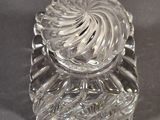 a clear glass object with a swirl design on it