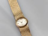 a close up of a gold wrist watch on a white surface