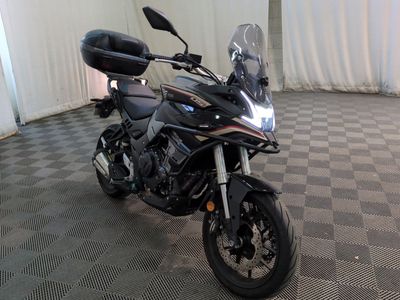 a black motorcycle parked in a room with a checkered floor