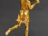 bronze statue of a woman holding a tennis racquet on a marble base