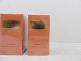 two boxes of perfume sitting on a table with a white background