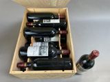 several bottles of wine are in a wooden box on a table