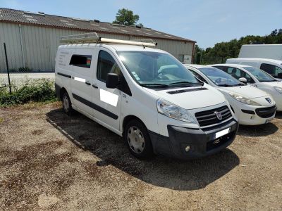 trois fourgonnettes blanches garées sur un parking à côté d'un immeuble