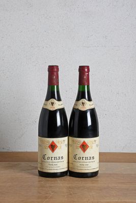 two bottles of wine sitting on a wooden table next to a bottle of wine