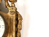 a gold clock with a bird on top of it