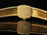 a close up of a gold bracelet on a black surface