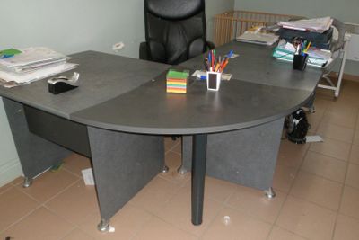 un bureau avec une chaise noire et une chaise noire dans un coin