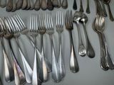 a lot of forks and spoons that are on the table