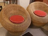 two wicker chairs with red cushions in a living room