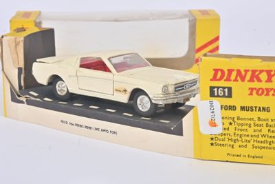 une petite voiture dans une boîte posée sur une surface blanche, avec une autre boîte à côté