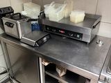 plan de travail en acier inoxydable dans une cuisine commerciale avec des casseroles et des poêles dessus