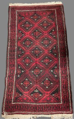 a red and black rug with a diamond design on it