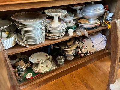 de nombreuses assiettes et casseroles empilées sur une étagère en bois