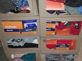 many boxes of clothes stacked on top of each other