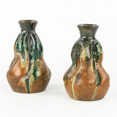 deux vases posés côte à côte sur une surface blanche