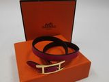 une ceinture violette et orange avec une boucle dorée, dans une boîte