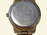 a close up of a wrist watch with a chain around it