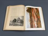 an open book with a picture of a house in the background
