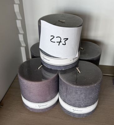 Plusieurs bougies sont empilées les unes sur les autres sur une table