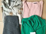 three pairs of tops and pants sitting on top of a cardboard box