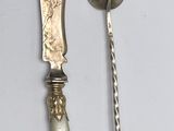 deux cuillères et un couteau sur une table blanche