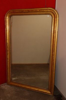 a mirror that is sitting on the floor in front of a red wall