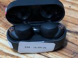 an image of a pair of black earphones sitting on top of a wooden table