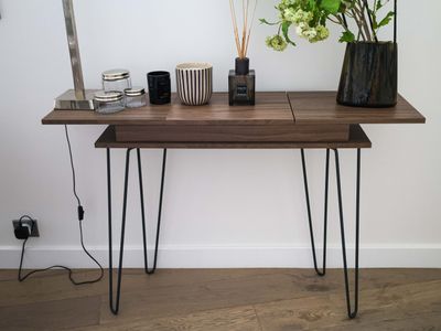 a wooden table with hairpin legs and vases on it