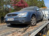 a blue car on the back of a flatbed tow truck