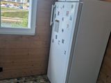 a refrigerator in the corner of a room with a window