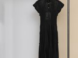 une photo d'une robe noire suspendue à un porte-vêtements