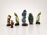 four different colored vases sitting on top of each other on a white surface