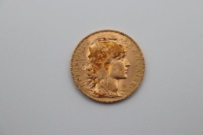 a close up of a gold coin with a woman ' s head on it