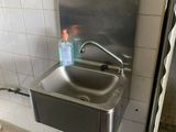 un lavabo dans des toilettes publiques, avec une bouteille d'eau à l'intérieur