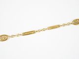 un bracelet plaqué or avec une pièce suspendue à une chaîne
