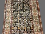 an antique persian rug with a floral design on a black ground