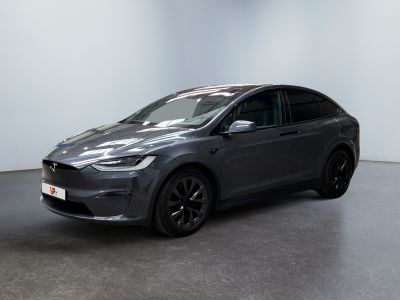 une Tesla Model X grise garée dans une pièce blanche