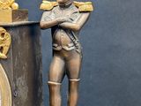 a statue of a man standing next to a clock