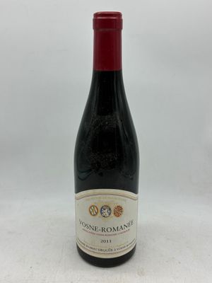une bouteille de vin posée sur une table blanche