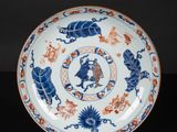 a blue and white plate with a design of lions and flowers