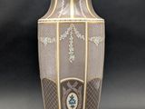a vase with a cross on it on a black background